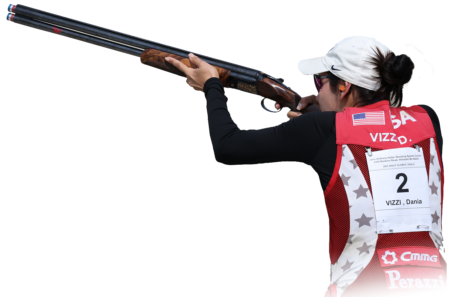 Female athlete wearing white ball cap and red vest aiming shotgun.