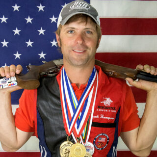 Frank Thompson, Olympic shooter wearing a red shirt with his many medals.