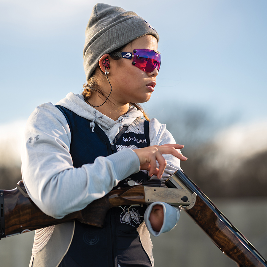 Young person wearing protective eyewear reloading a gun