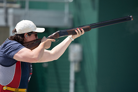 A female shooter aims a rife on the range.